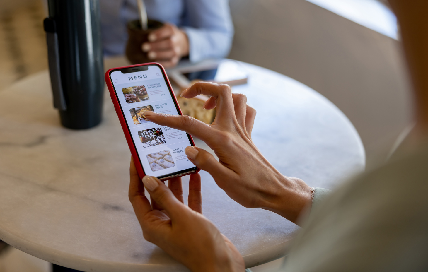 Woman at a cafe looking at a digital menu